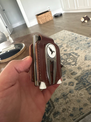 Brown leather key organizer with multiple keys held in a hand, indoor setting.