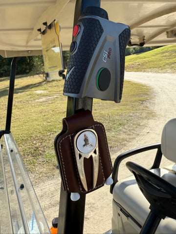 Close-up of a golf club head cover and driver on a golf cart with a blurred background